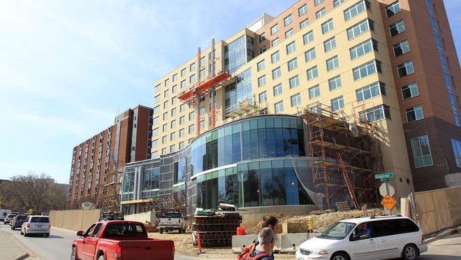 Vehicles pass the nearly finished $53 million Mary Louise Petersen Residence Hall at the University of Iowa on Thursday. The dormitory, UI’s first since 1968, is set to open for fall semester.