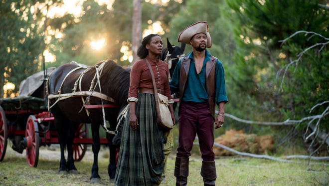 This image released by Entertainment One/BET shows Aunjanue Ellis, left, and Cuba Gooding Jr. in a scene from "The Book of Negros," a six-part miniseries.