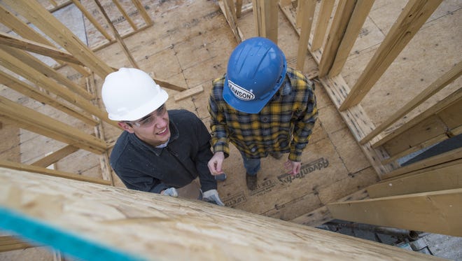 Poudre High School student Sebastian Wells works to install a wall in a home he and his classmates were building Friday, November 20, 2015. Students enrolled in the geometry in construction course are building a home with Habitat for Humanity.
