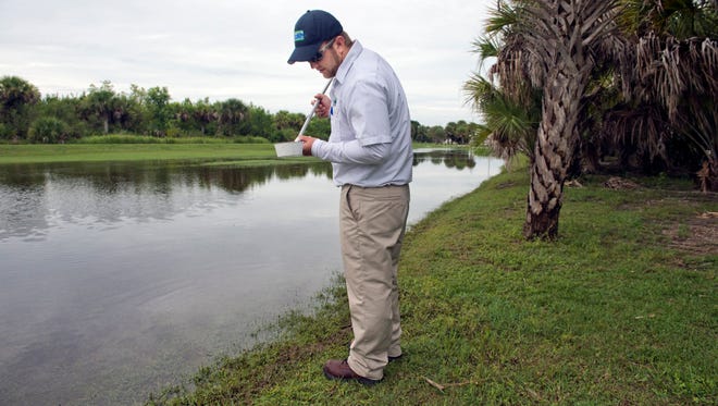 Scott Artman, St. Lucie County Mosquito Control inspection foreman, takes a water sample from a pond Wednesday near the Stan Blum Memorial Boat Ramp Wednesday, August 31, 2016, in Fort Pierce. Artman uses several methods to determine the presence of adult mosquitos and their larvae. A treatment plan for the area is developed based on his findings.