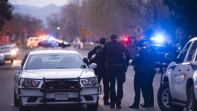 Law enforcement personnel including Larimer County Sheriff's Office deputies work in the 900 block of E. 4th St. in Loveland after a suspect barricaded himself inside a home February 21, 2016.