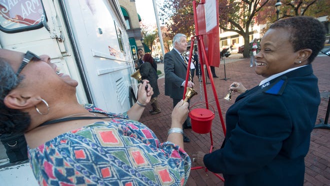 Norma Escobar, left, and Marietta Foust, with the Salvation Army, have some fun while they ring bells to kick off the annual Red Kettle Campaign in Continental Square in York. The kettles will be placed throughout the county until Dec. 24 with all donations going to help fund programs and services for those in need.