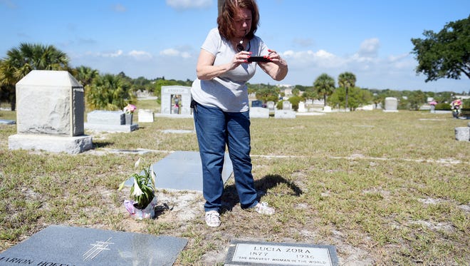 Mari-Lynn Enns Herringshaw takes a photo of the new grave marker unveiled Monday, April 24, 2017, for Lucia Zora, a famed local circus animal trainer billed as 'The bravest woman in the world' at Riverside Memorial Park in Fort Pierce. The grave remained unmarked since Zora's death in 1936 until Fort Pierce Mayor Linda Hudson, along with her sister Jean Wilson, discovered the gravesite while conducting genealogical research.