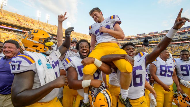 LSU head coach Ed Orgeron, left, smiles as place kicker Connor Culp (34) is lifted on the field by teammates Jibrail Abdul-Aziz (58) and Cameron Gamble (36) after kicking the winning field goals in their 27-23 victory against Auburn in an NCAA college football game in Baton Rouge, La., Saturday, Oct. 14, 2017.