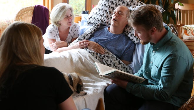 Dr. Peter Rasmussen lies in bed listening to one of his favorite childhood  fairy tales by Hans Andersen with his stepdaughter, Gretchen; wife, Cindy and stepson, Keith, Thursday, Oct. 8, 2015, at his Salem, Ore., home. Rasmussen, a retired oncologist and advocate for physician aid-in-dying, died Nov. 3, using Death with Dignity.
