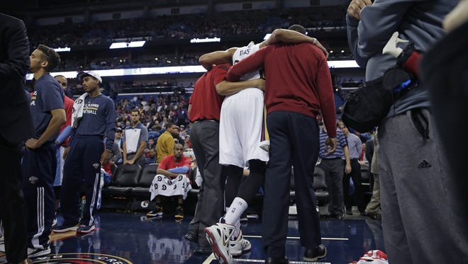 New Orleans Pelicans forward Anthony Davis (23) is helped off the court after pulling his groin in the second half of an NBA basketball game against the Denver Nuggets in New Orleans, Wednesday, Jan. 28, 2015. The Nuggets won 93-85. (AP Photo/Gerald Herbert)