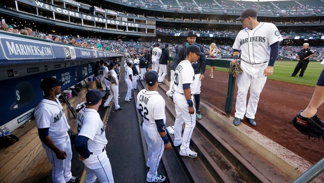 Seattle Mariners line up to head out of the dugout and onto the field before a baseball game against the Kansas City Royals Wednesday, June 24, 2015, in Seattle.