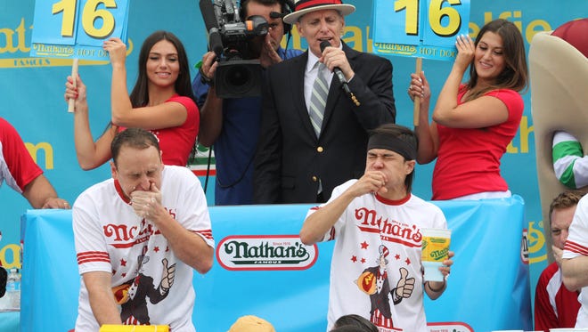 Joey Chestnut, left, and Matt Stonie compete in Nathan's Famous Fourth of July International Hot Dog Eating Contest men's competition Saturday July 4, 2015 in the Coney Island section in the Brooklyn borough of New York. Stonie came in first eating 62 hot dogs and buns in 10 minutes. Chestnut came in second eating 60 hot dogs and buns in 10 minutes. (AP Photo/Tina Fineberg)