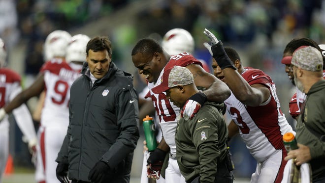 Arizona Cardinals defensive end Cory Redding (90) is helped off the field in the first half of an NFL game against the Seattle Seahawks, on Sunday, Nov. 15, 2015, in Seattle.