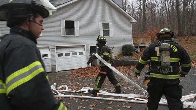Putnam Lake and Patterson firefighters work at the scene of a house fire. The town is considering consolidating the two departments and has received a state grant to explore doing so.