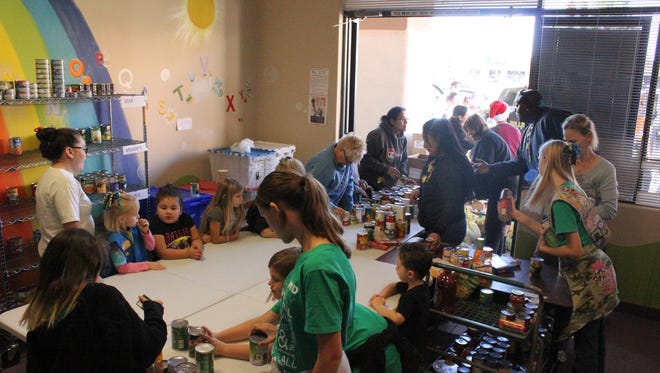 Girls Scouts and volunteers at The Salvation Army organize food at the Boy Scout Food Drive Saturday morning.