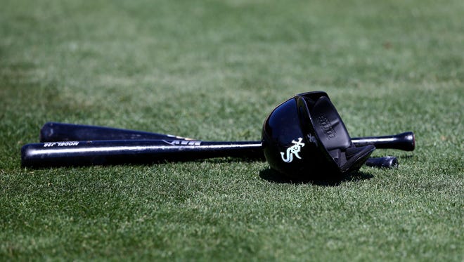 Detailed view of Chicago White Sox baseball bats and batting helmet on the field during a 2015 spring training game at Camelback.