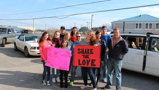 Adams, center, along with her close group of family and friends traveled around Pensacola Sunday as part of the Share the Love campaign, that involves handing out food and toiletries to people in the community who are in need.