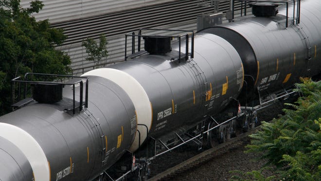 Tank cars on a Norfolk Southern freight train roll through downtown Pittsburgh, Monday, July 28, 2014.