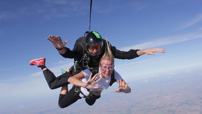 IU student Kelsey Haas skydives with an assist from a staff member of Skydive Indianapolis. Attached to her is a stuffed bear that will be donated to a Riley Hospital patient. Haas and 45 participants in IU's Dance Marathon were raising money and awareness for this year's marathon, which supports Riley Hospital for Children at IU Health.