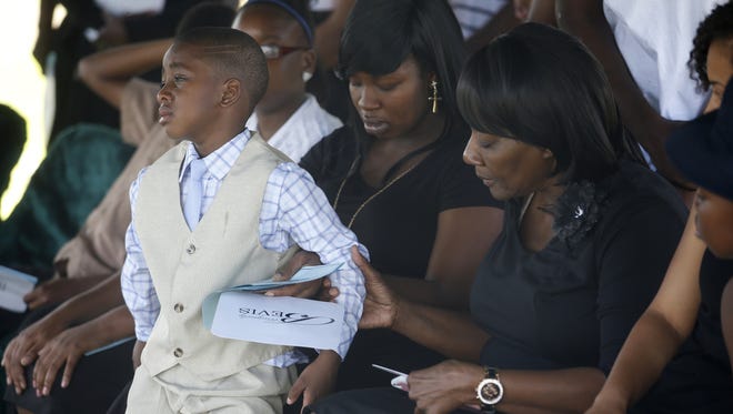 Eric Nealy III, 4, cries with his mother Tateyana Smith’s behind him during the funeral of his 10-month-old baby brother, Jeffery Lamar Phillips III, at the Southside Cemetary where the infant will be laid to rest on Saturday, May 21, 2016.