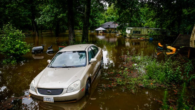 A car and home sit in flood water from Spring Creek along North Ravenswood Drive, Friday, May 27, 2016, in Magnolia, Texas. (Michael Ciaglo/Houston Chronicle via AP) MANDATORY CREDIT