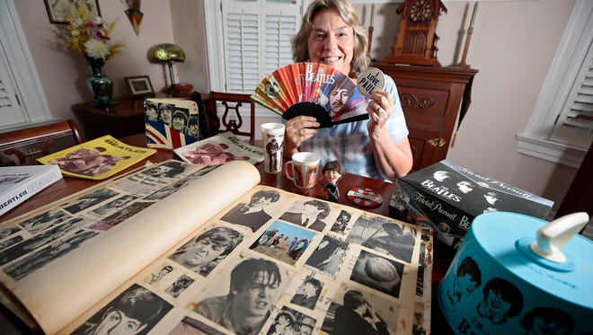 Life-long Beatles fan Julie Hemmert poses with a portion her Beatles and Paul McCartney collection which she's amassed over more than 50 years at her home in Norwood, Ohio, Tuesday, July 5, 2016. Hemmert describes meeting McCartney in 2010, where she received a kiss on the cheek from the star, as the happiest night of her life.