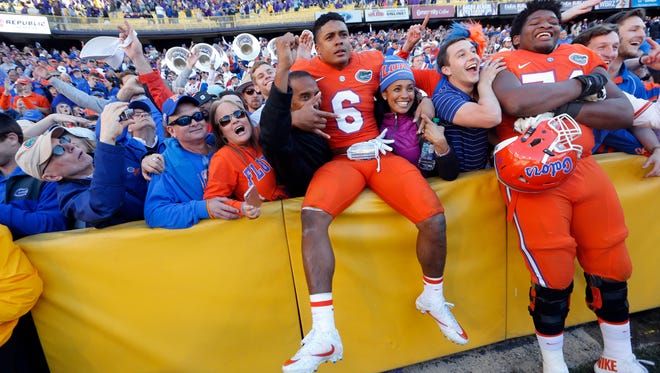Florida defensive back Quincy Wilson and offensive lineman Fred Johnson celebrate with fans after defeating LSU on Saturday in Baton Rouge, La.
