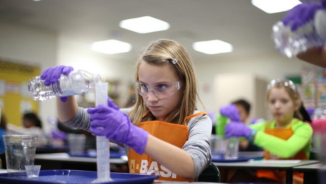 Addy Cox, a 5th grader at Hawks Rise Elementary, conducts a chemical reaction experiment with the help of BASF in an excel science class at the school on Tuesday Dec. 13, 2016. 