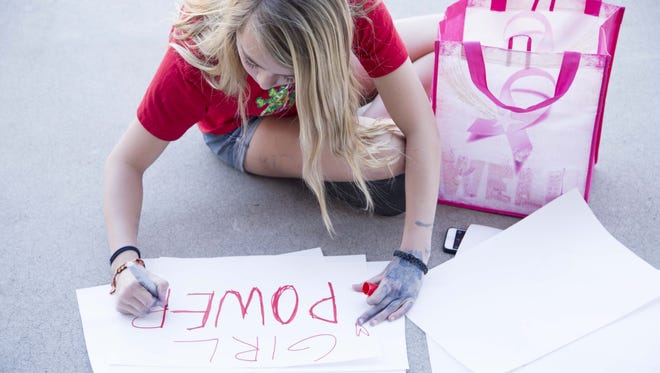 Sally D'Arcangelo, 13, makes signs while she joined other women who came to Arizona State Capitol to act together for equity, justice and the human rights of women and all gender-oppressed people, through a 1 day demonstration of economic solidarity during  International Women's Day on March 8, 2017.