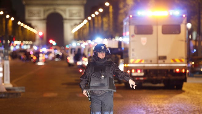 A police officer stands guard after a fatal shooting in which a police officer was killed along with an attacker on the Champs Elysees in Paris, France, Thursday. The gunman, later identified as French national Karim Cheurfi, was a known criminal with a long, violent record. ISIS claimed to be behind the attack. (AP Photo/Thibault Camus)