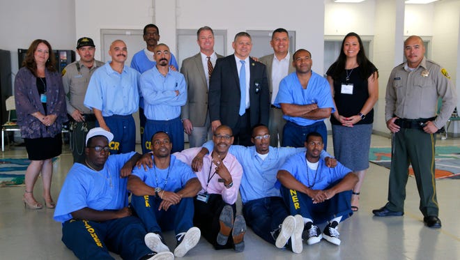Inmates and staff at Salinas Valley State Prison pose for a photo with staff from Camp Grace.