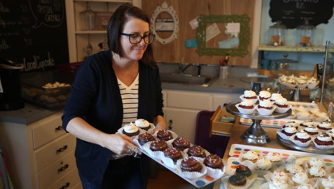 Lucy & Leo's Co-owner Paula Lucas puts out cupcakes at the cupcakery's storefront on Thomasville Road Thursday, Sep 14.