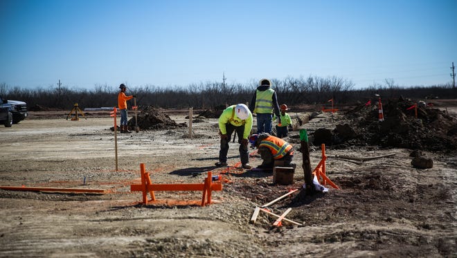 Workers mark areas for construction at the AEP San Angelo Service Center Tuesday, Jan. 30, 2018, at the Industrial Park.
