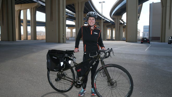 Monica Quesnell stands with her bike under the Milwaukee freeway she used to patrol as a sheriff's deputy. She found that job too traumatic and now plans to take a 2,400-mile bike ride across the western U.S.