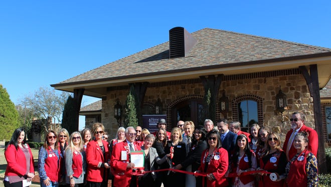 The Abilene Chamber of Commerce Red Coats celebrate the opening of the relocated Home Instead Senior Care.