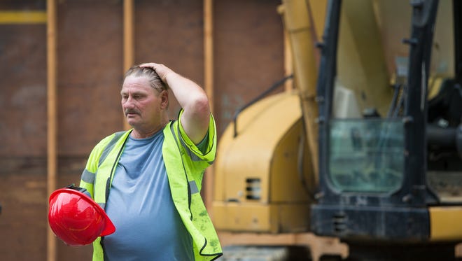 A construction worker wipes the sweat from his fourhead as he works in the 91-degree heat along North King Street in Wilmington in 2018.