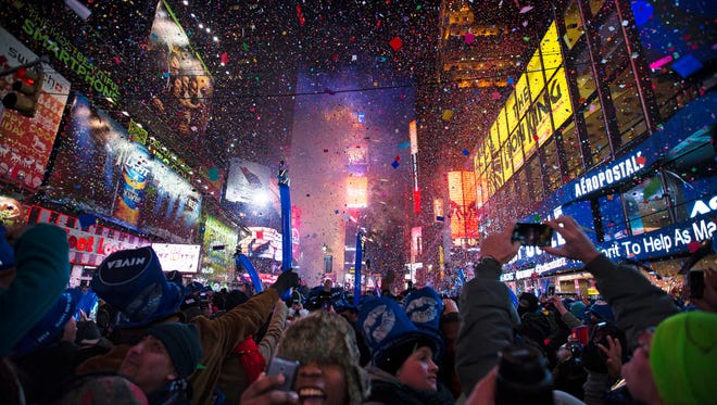 Revelers cheering under falling confetti at the stroke of midnight during the New Year's Eve celebrations in Times Square, in New York on Jan. 1, 2014. Americans are closing out 2014 on an optimistic note, according to a new Associated Press-Times Square Alliance poll. Nearly half predict that 2015 will be a better year for them than 2014 was, while only 1 in 10 think it will be worse. There’s room for improvement: Americans give the year gone by a resounding ‘meh.’
