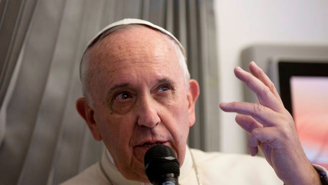 Pope Francis talks with reporters during his flight from Sri Lanka to Manila, Philippines Thursday, Jan. 15, 2015.