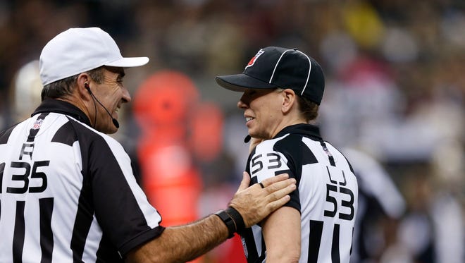 referee Peter Morelli (135) talks with line judge Sarah Thomas (53) in the second half of an NFL football game between the New Orleans Saints and the Detroit Lions in New Orleans, Monday, Dec. 21, 2015.