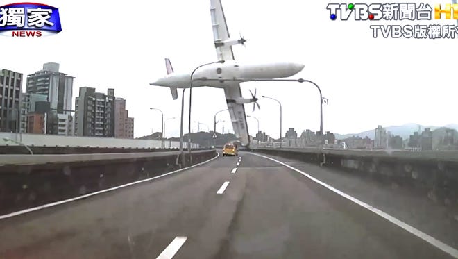 Image taken from video provided by TVBS shows a commercial airplane clipping an elevated roadway just before it careened into a river in Taipei on Wednesday.