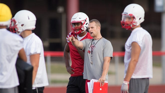 Chippewa Valley High School senior DB/WR Stefan Claiborne, left, talks with LB/Special Teams coach Don Preiss, right, during practice at in Clinton Township on Monday, August 10, 2015.