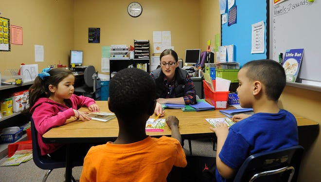 Kelsey Ellens, LIA Teacher, reads with Estrella Castaneda, Gamr Dokman and Tariku Tamire at Terry Redlin Elementary in Sioux Falls, S.D., Monday, Feb. 22, 2016. 