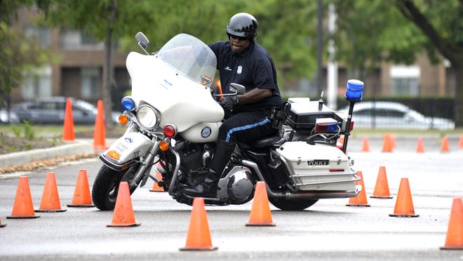 Detroit Police Department Motor Unit Officer Juan "Magic" Windham navigates his Harley-Davidson Police Special motorcycle through a course on the Police Motorcycle Challenge Course duringt he first annual Field Day at Wayne State University athletic fields on Saturday.