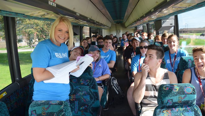 Christy Rowden of Evangel University with one of several busloads of new Evangel University students volunteering Saturday, Aug. 19, 2017, in the Springfield community. This is an annual partnership with Convoy of Hope’s Neighbor’s Helping Neighbor’s program, in the Zone 1 neighborhoods.