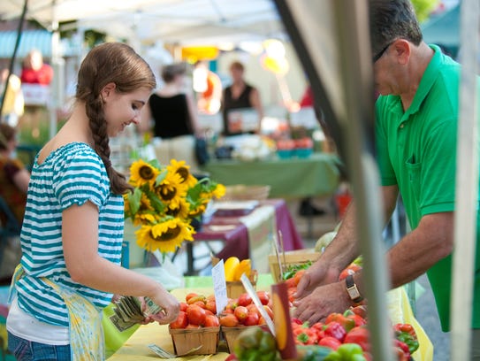 A vendor sells produce at the Westmont Farmers Market.