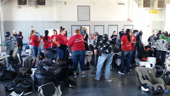 Volunteers take apart car seats at a Phoenix Fire Station.