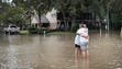 Friends reunite in the middle of a flooded intersection