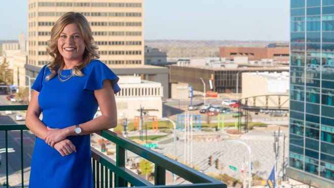 Newly elected president of Downtown Topeka Inc. Rhiannon Friedman smiles Thursday from the balcony of the Greater Topeka Partnership offices overlooking downtown Topeka and Evergy Plaza. Friedman served as GO Topeka's vice president of business development before accepting the position after current president, Vince Frye, announced his retirement in September.