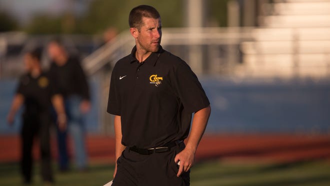 Gilbert offensive coordinator Max Hall looks over the team before it starts a game against Mesquite on Aug. 28, 2014.