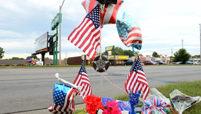 Two roadside memorials sit on opposite sides of Cedar Street honoring fallen firefighter Dennis Rodeman Thursday night, September 10, 2015. Rodeman was killed after he was hit by a vehicle while collecting donatoins for the "Fill the Boot" campaign on Wednesday. 