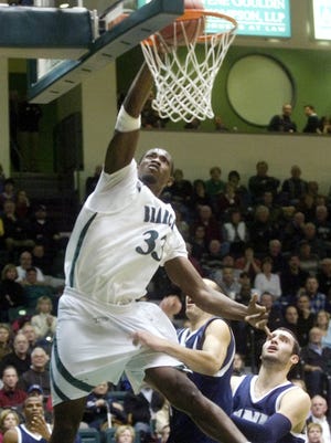 Former Binghamton University center Kyrie Sutton, left, dunks the ball past University of New Hampshire's Dane DiLiegro, right, and James Valladares during a game at the Events Center in 2010.