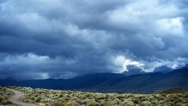 A file photo showing a spring storm rolling over the Sierra Nevada Mountains as seen from Huffaker Park in early June in Reno.