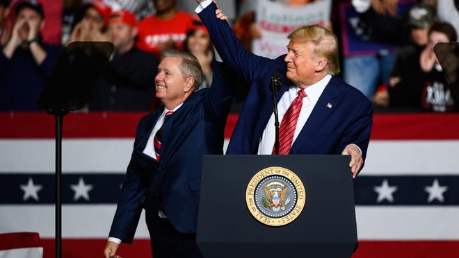 President Donald Trump cheers with Sen. Lindsey Graham during a rally at the North Charleston Coliseum Friday, Feb. 28, 2020.