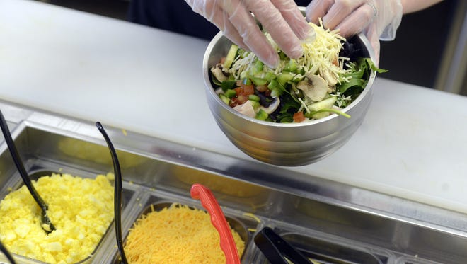 Mixed?s menu includes salads that are freshly chopped and topped with ingredients that customers can choose.
 Argus Leader file photo
Courtney Knudson prepares a salad for a customer Friday at Mixed in Sioux Falls, April 26, 2013.

(Elisha Page/Argus Leader)